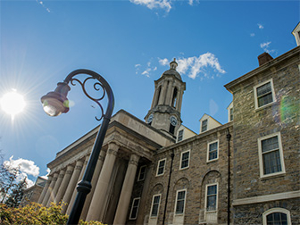 Penn State Old Main building with sunny sky