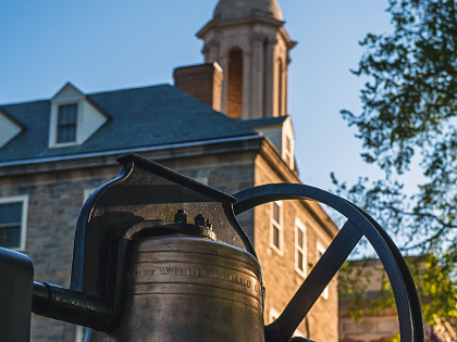 A photo of a bell in front of Old Main on the University Park campus