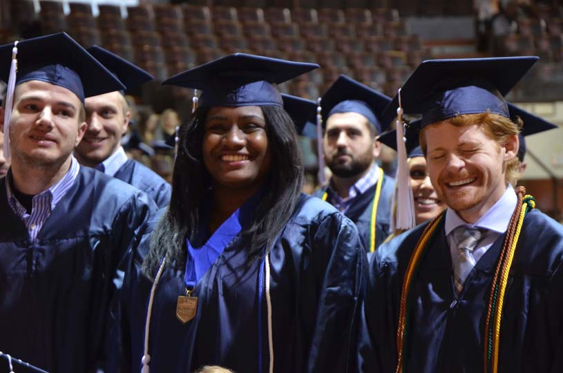 Graduates smile and laugh during a speaker’s address at a Penn State Altoona Commencement ceremony.