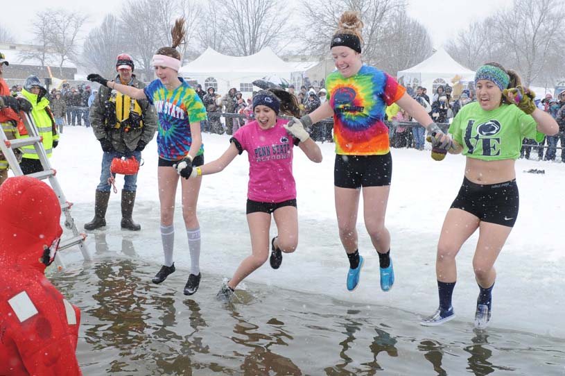 Penn State Altoona students dive into the frozen waters of nearby Canoe Creek State Park as part of the annual Winter Plunge.