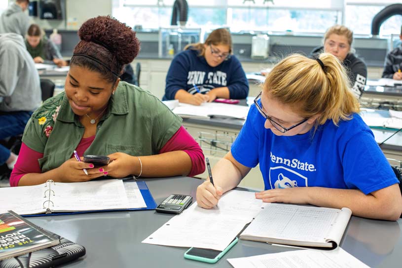 Students calculate math problems during a chemistry lab at Penn State Beaver.