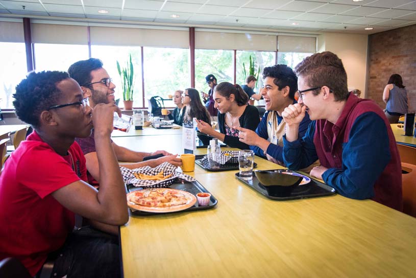 Students eating a meal at a table inside Behrend’s Dobbins Dining Hall