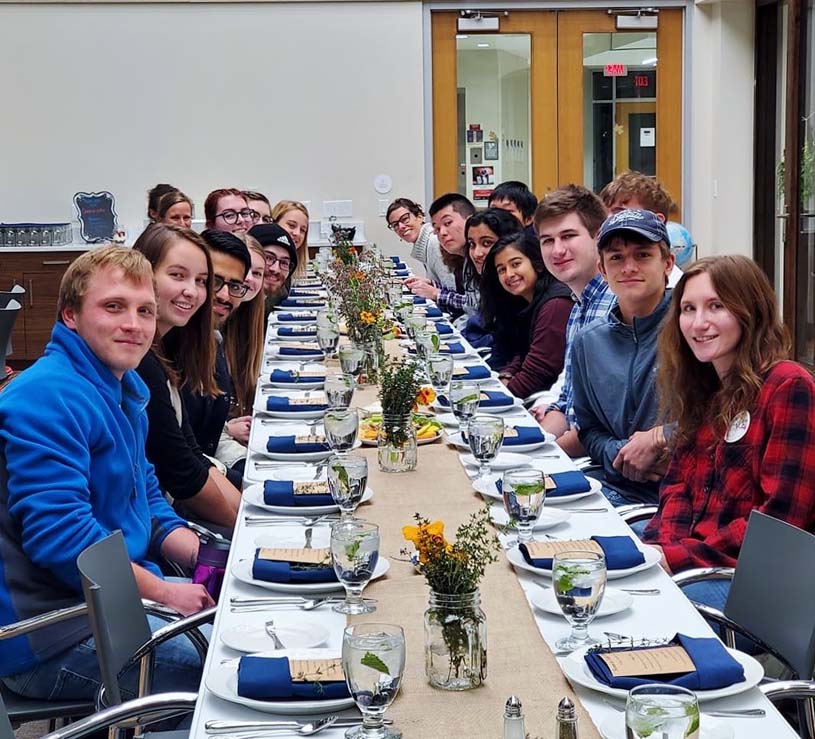 Students sitting at a long dinner table