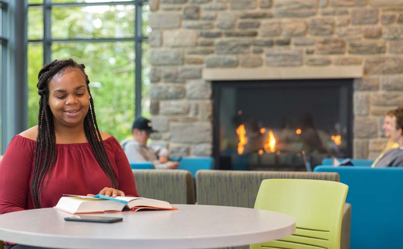 A student studies at a table in a campus lounge on Brandywine’s campus.