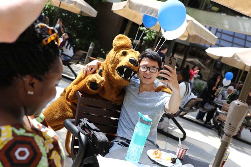 A Brandywine student gets a photo taken with Penn State's Nittany Lion mascot at a student event.
