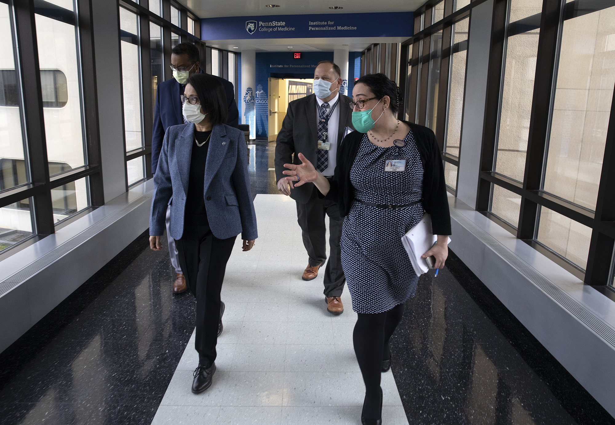 Neeli Bendapudi walks down a hallway with a woman and two men at the Penn State Health Milton S. Hershey Medical Center.