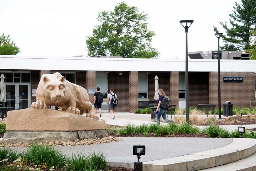 Penn State Fayette students walk past the Lion Shrine statue and into the Williams Building on campus.