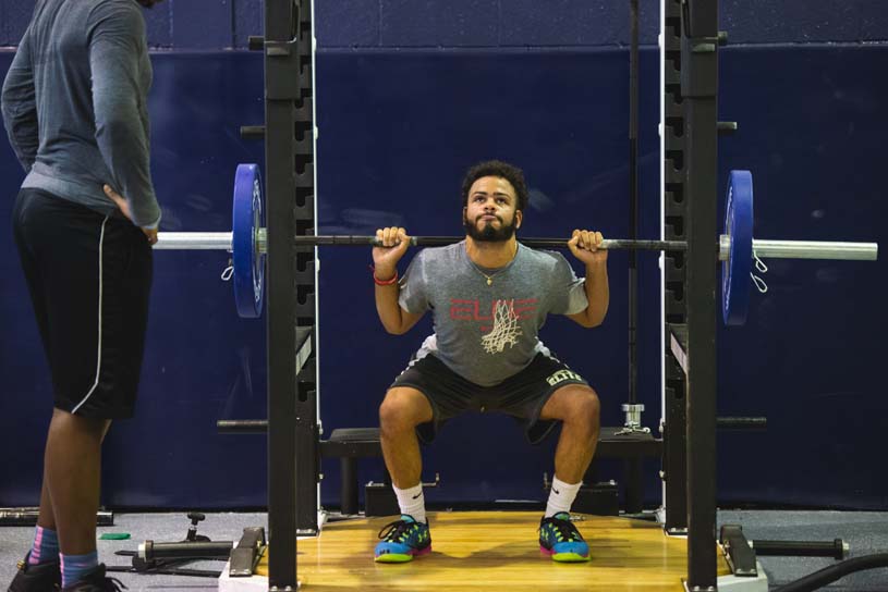 A Greater Allegheny student is benching weights in the Regis W. Becker Strength and Conditioning Center on campus while another student spots.
