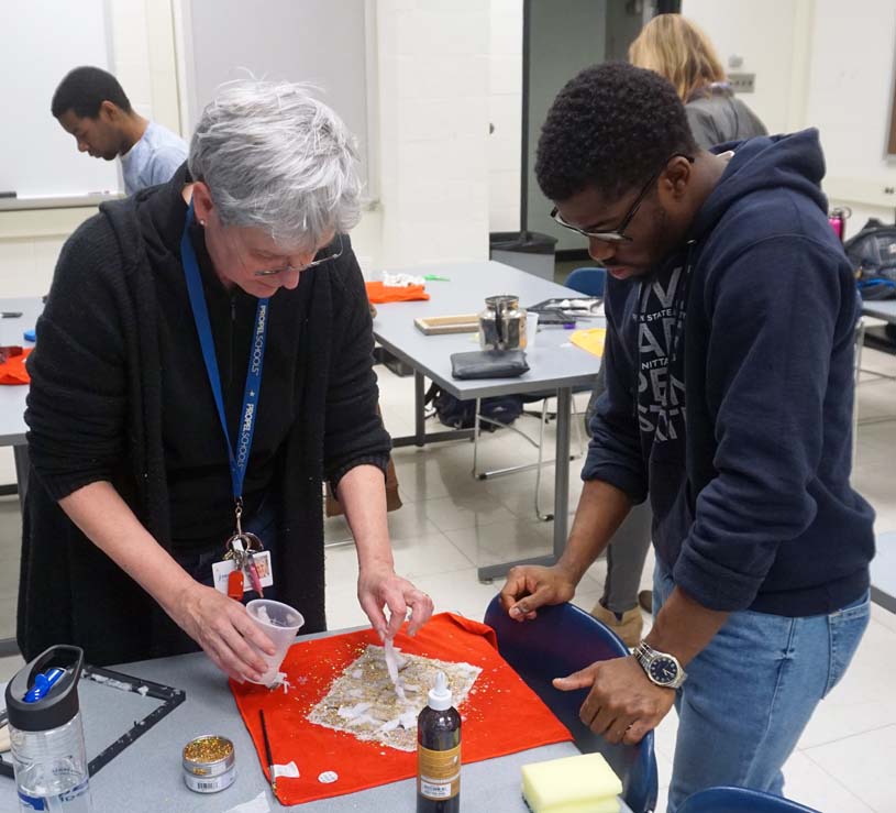Student and faculty member work on an art project together.