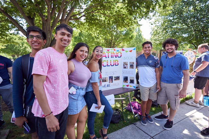 A group of Harrisburg students pose for a photo in front of a poster board that reads “Latino Club.”