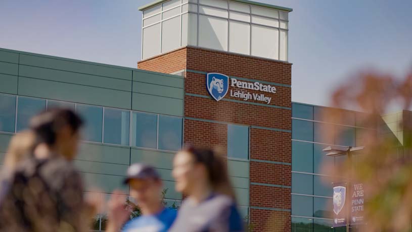 Students standing outside on a sunny day in front of the Penn State Lehigh Valley Campus building.