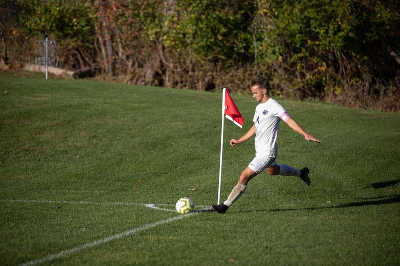 A New Kensington men’s soccer team player readies to kick soccer ball onto the field.