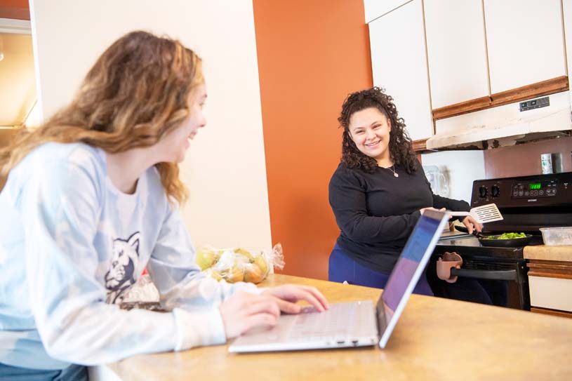 Two students cook food and study in their  Schuylkill campus apartment.