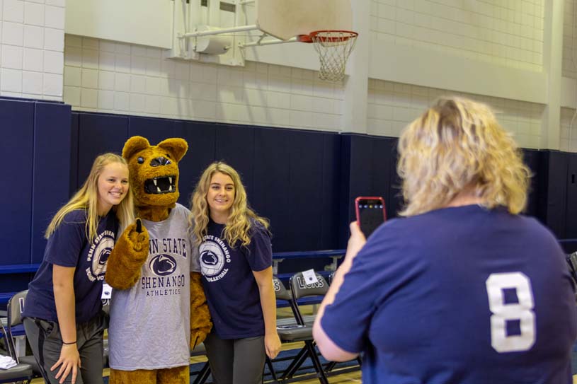 Two members of the Penn State Shenango women’s volleyball team have their photo taken with the Nittany Lion Mascot at Buhl Club’s gymnasium.