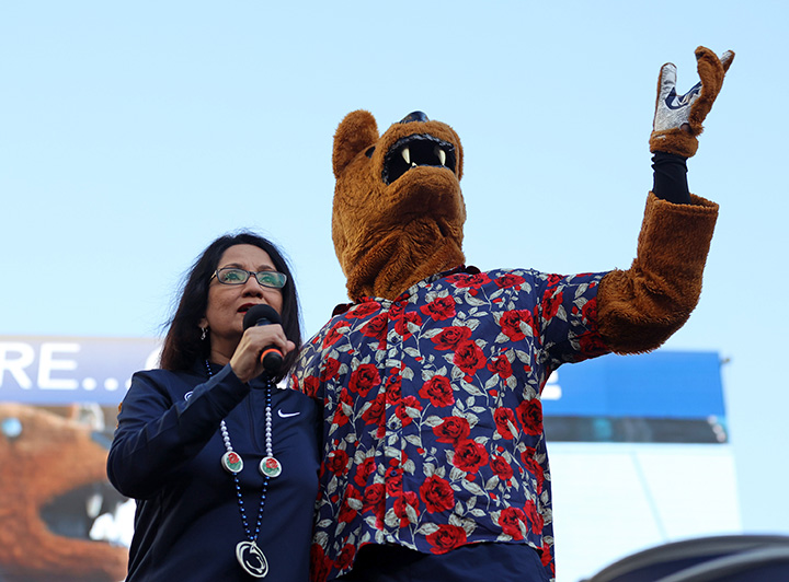 Neeli Bendapudi and Penn State’s Nittany Lion mascot stand together to address a crowd the Rose Bowl Pep Rally