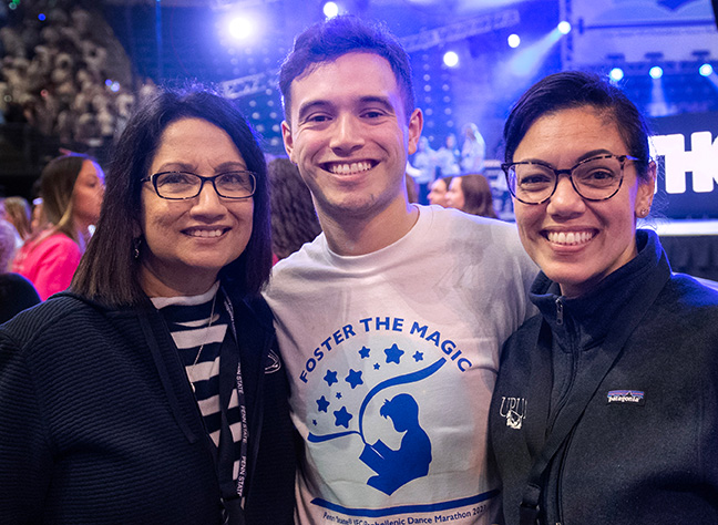 Neeli Bendapudi smiles and poses with two THON participants in the Bryce Jordan Center.