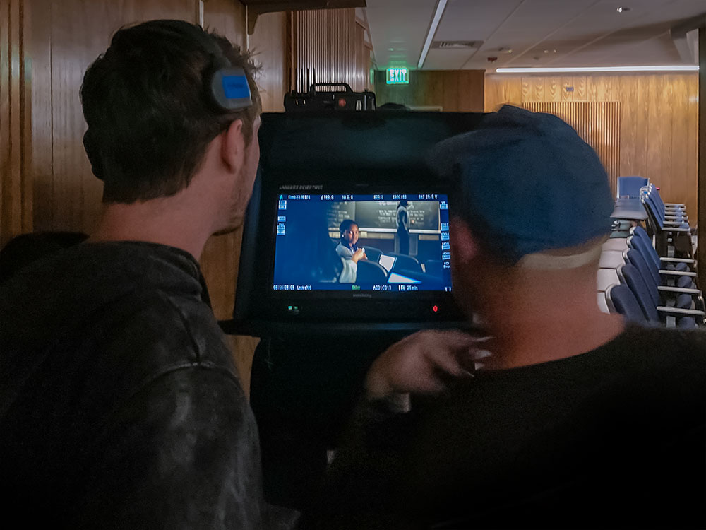 Video crew members looking at a monitor displaying footage of Jasmine Ward