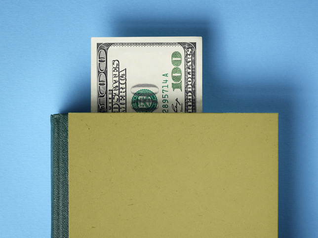 Hundred dollar bill sticking out of book