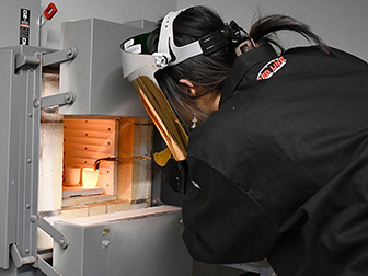 A student makes glass in a forge